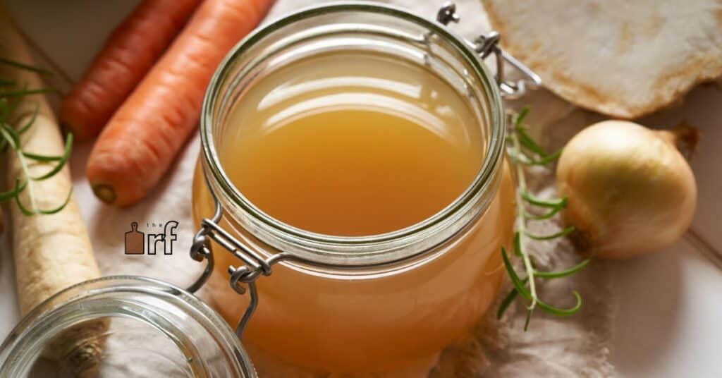 jar of vegetable broth with veggies nearby