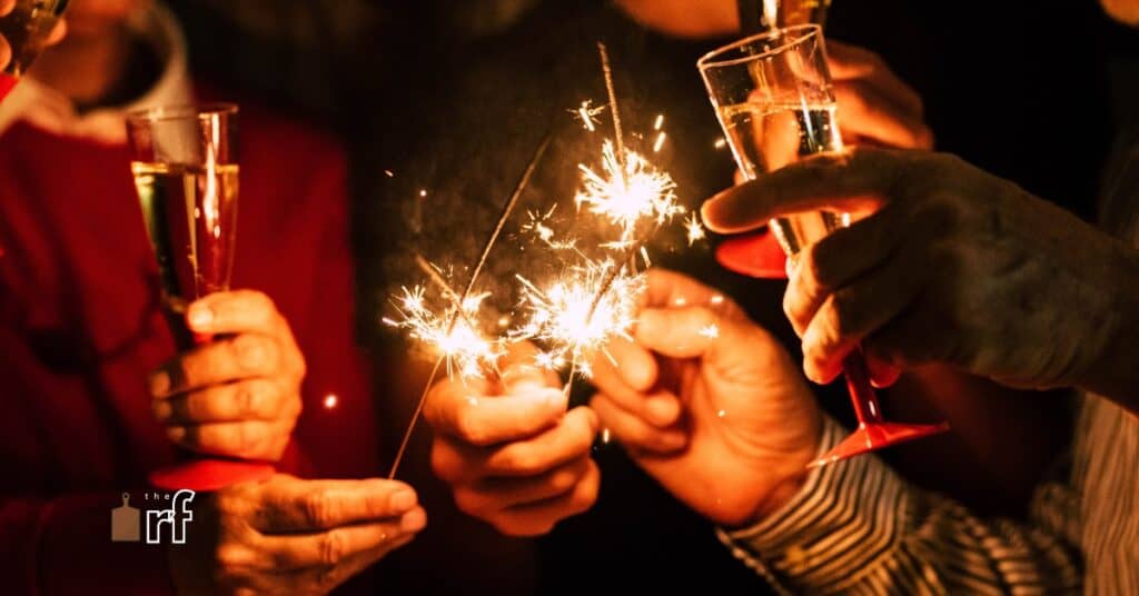 hands holding sparklers and champagne