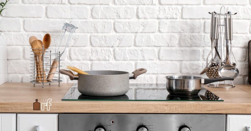 kitchen cooktop with pans and utensils